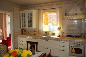 雷杰洛卢克雷齐亚别墅的厨房配有白色橱柜、水槽和窗户。