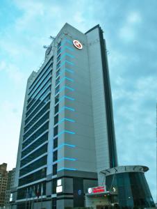 迪拜拉米玫瑰酒店的一座高大的蓝色建筑,上面有时钟