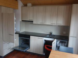 林根贝格Royal Swiss Apartments的厨房配有白色橱柜、水槽和炉灶。