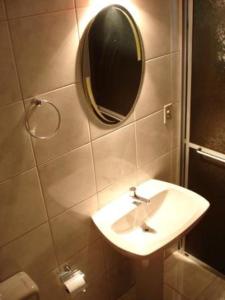 新彼得罗波利斯Pousada Félix的浴室设有水槽和墙上的镜子