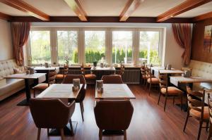 马兰迪加尼戴安娜酒店的餐厅设有桌椅和大窗户。