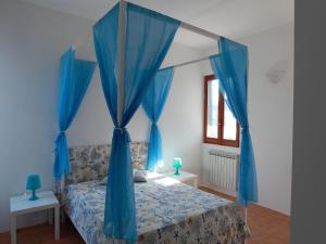 托雷苏达Villa Giordano的一间卧室配有蓝色天蓬床和蓝色窗帘