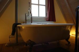 奈梅亨De Hemel De Kracht van Ambacht的带浴缸的浴室和窗户