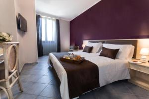 皮雅诺迪索伦托索雷卢娜酒店的一间卧室配有一张大床和紫色墙壁