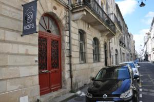 波尔多HOSTEL20 Bordeaux HIFRANCE的停在大楼旁的红色门的汽车
