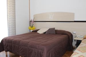 安达洛阿罗佐迪雅克酒店的一间卧室配有一张带棕色毯子的大床