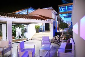 多列毛利诺斯阿诺斯50酒店的一个带紫色椅子和桌子的庭院和一座建筑
