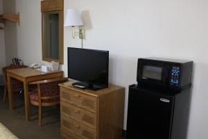 弗拉格斯塔夫弗拉格斯塔夫海兰德乡村旅馆的客房配备了带小冰箱的梳妆台上的电视