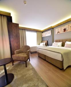 伊斯坦布尔The Elegant Hotel的配有一张床和一把椅子的酒店客房