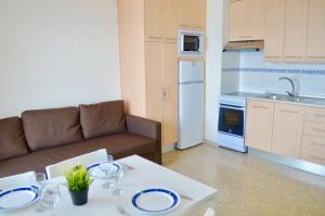 圣地亚哥港海洋全景公寓的厨房配有沙发和一张桌子及盘子