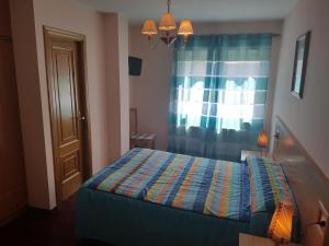 Becerreá卡萨蕙旅馆的一间卧室配有一张带窗帘的床和窗户