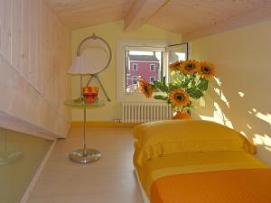 布拉诺岛卡萨诺瓦度假屋的一间卧室配有一张黄色的床和向日葵花瓶。
