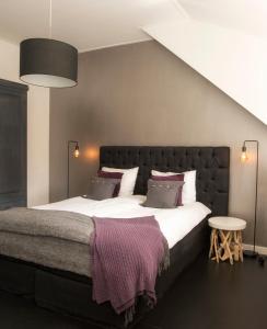 OosterwoldeB&B Buitenplaats Natuurlijk Goed的卧室配有一张带白色床单和枕头的大床。