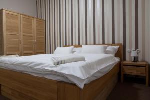 克尔诺夫Villa Cafe的卧室配有一张带白色床单和枕头的大床。