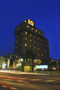 东村山市久米川翼酒店的一座建筑物,上面有夜间标志