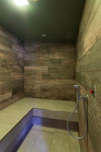 多尔梅莱托Hotel Le Palme的配有木墙的客房内的淋浴