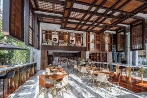 曼谷曼谷137柱套房酒店的一间带桌椅的餐厅和一间酒吧