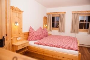 阿尔滕马克特蓬高Bifeis Hütte的一间卧室配有红色和白色枕头的床