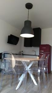 加尔达湖滨Appartamento Brione的餐桌、清澈的椅子和灯具