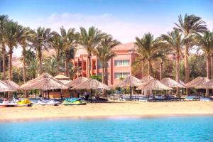 艾因苏赫纳Kefi Palmera Beach Resort El Sokhna - Family Only的一个带遮阳伞和棕榈树的海滩的度假村
