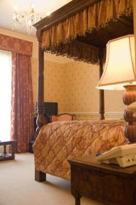 诺里奇Stower Grange Hotel的一间卧室配有一张床和一张带台灯的桌子