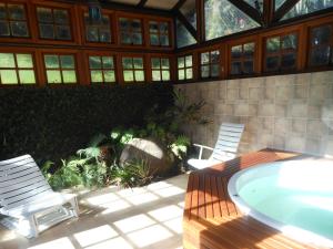 圣弗朗西斯科-迪保拉Pousada Refúgio do Lago的一个带两把椅子和热水浴缸的庭院