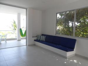 科韦尼亚斯Condominio Milagros Coveñas的配有大窗户的客房内的蓝色沙发