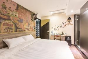 台北RF富裕自由旅店 - 林森馆的卧室配有一张白色大床和一张书桌