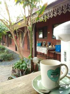 乌汶Rim Than View Resort的坐在桌子上喝杯咖啡