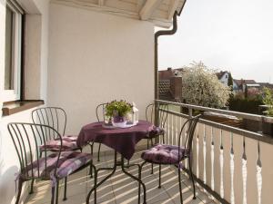 鲁斯特Ruster Drachennest的阳台配有两把椅子和一张鲜花桌子