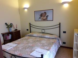 莫诺波利Villa Capitolo的卧室配有一张床,墙上挂着一幅画