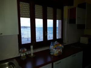 莫诺波利Villa Capitolo的厨房设有3扇海景窗户。