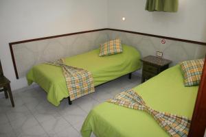 英格兰海滩Apartamentos Maba Playa的配有绿床单的客房内的两张床
