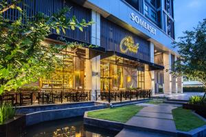 曼谷Somerset Ekamai Bangkok的一座配有桌椅的建筑前的商店