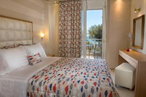 尼亚·卡利克拉提亚Georgalas Sun Beach Resort的一间卧室设有一张大床和一个大窗户