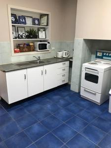 布罗肯希尔亚丹山林小屋的厨房配有白色炉灶和蓝色瓷砖地板。