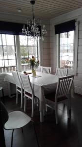 蓬卡哈尤Villa Paradise at Puruvesi Saimaa的白色的用餐室配有白色的桌椅