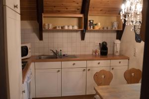朗克维茨Reetdach-Ferienhaus in Quilitz的厨房配有白色橱柜和水槽