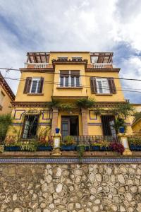 马拉加阿里西亚别墅旅馆的黄色的房子,设有窗户和阳台,位于石墙上