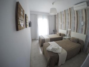 滨海托萨Hostal del Mar的酒店客房设有两张床和窗户。