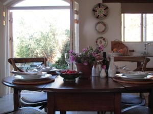 弗朗斯胡克The Cottage @ Montpellier的餐桌上摆放着盘子和果盘