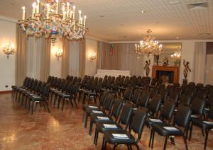乌迪内意大利阿斯托瑞亚酒店的一间带椅子和吊灯的会议室