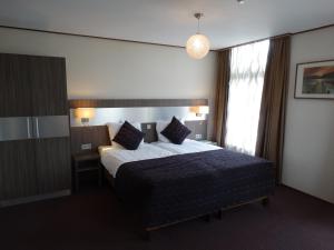 Hoogezand法贝尔酒店的酒店客房设有床和窗户。