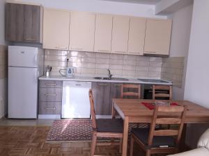 普里什蒂纳Apartment Gashi的厨房配有桌子和白色冰箱。