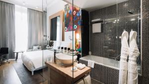 日内瓦日内瓦梅特罗博尔酒店的一间带水槽和淋浴的浴室以及一张床