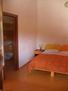 OraniAgriturismo Usurtala的一间卧室配有一张床,浴室设有卫生间