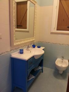 托雷斯佩基亚鲁杰里Villa Maria的浴室配有蓝色水槽和卫生间。