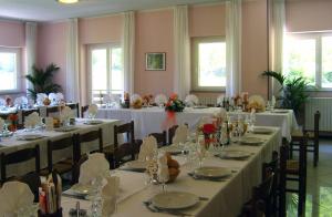 Val MasinoHotel Ristorante Sasso Remenno的宴会厅配有桌椅和白色的桌布