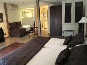 拉加里加Hotel Calabria的酒店客房设有一张大床和一张沙发。