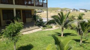 洛斯拉甘斯Villa Sunset Beach Peru的庭院前有棕榈树的房子